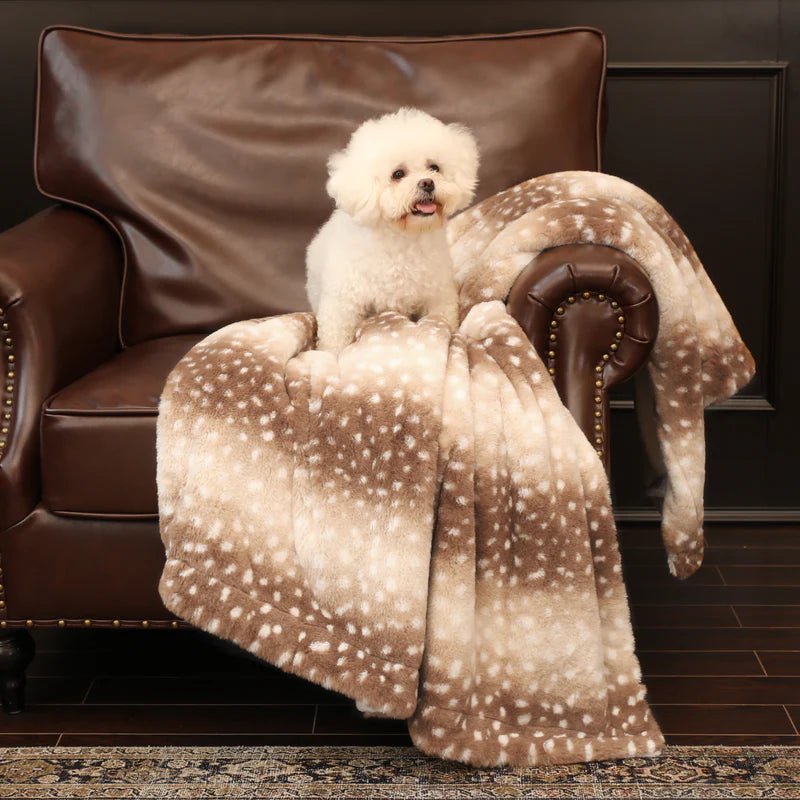 Cozy plush faux fur deer blanket draped on a bed, reversible throw for ultimate bedroom warmth & style.