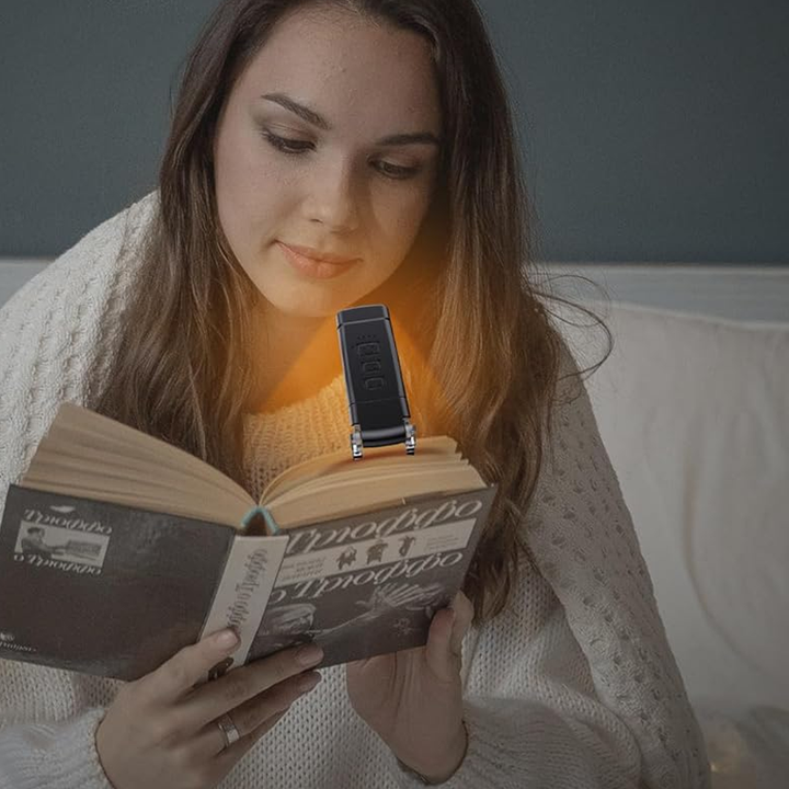 LED reading light with a sturdy clip base, securely fastened to a thick textbook
