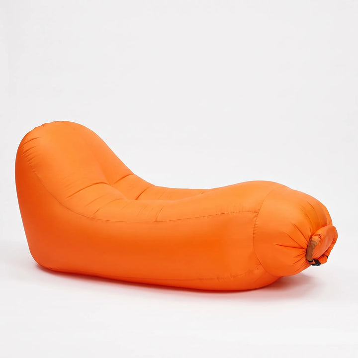 Compact & portable inflatable lounge chair in a carrying bag, ready for travel, beach trips, or outdoor adventures.