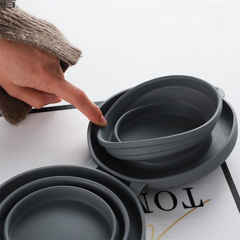 Pet travel diner set unfolded on a park path, blue silicone bowls filled with food and water