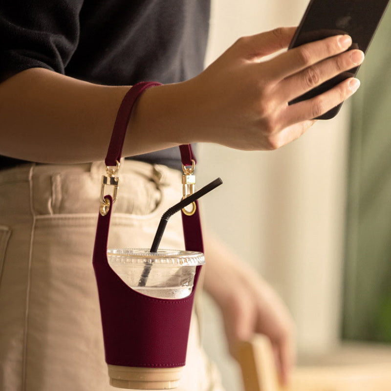 Vegan leather cup holder in black, designed for hands-free carrying of coffee or travel mugs