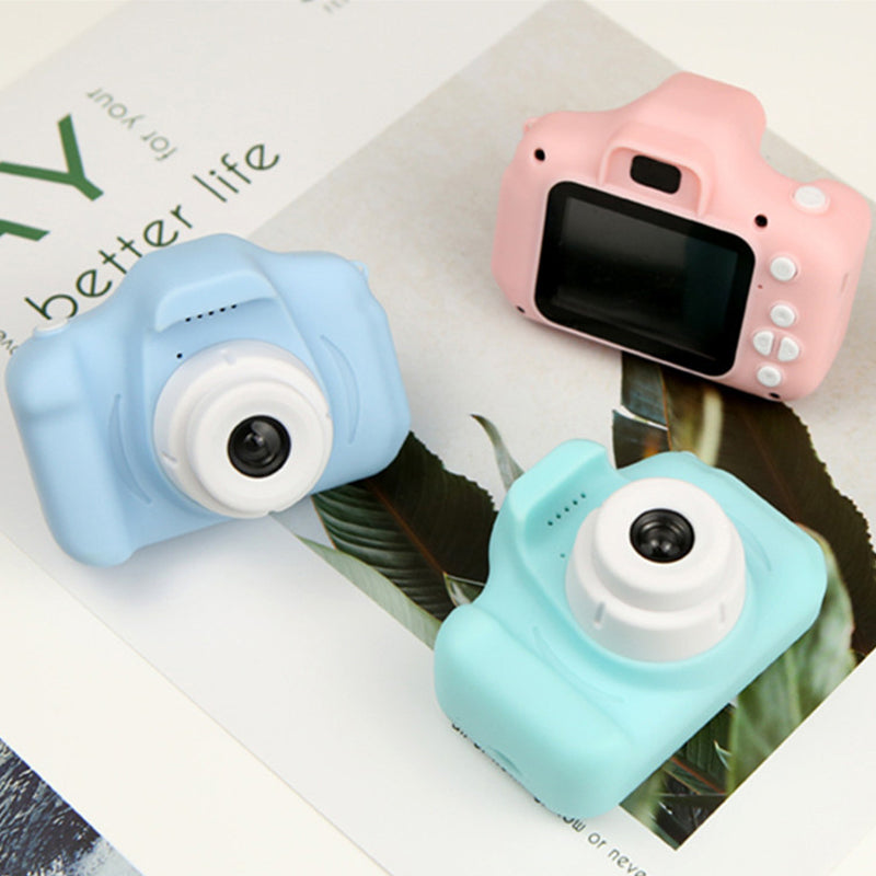 A child's hand holding a purple reusable mini digital camera, ready to take a picture, emphasizing portability.