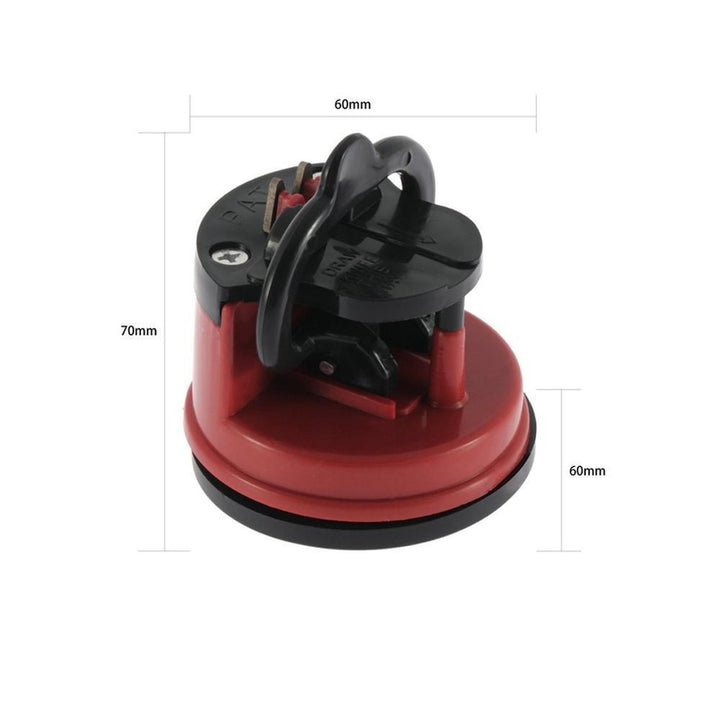 Close-up of red kitchen knife sharpener showing the sharpening slot and suction base