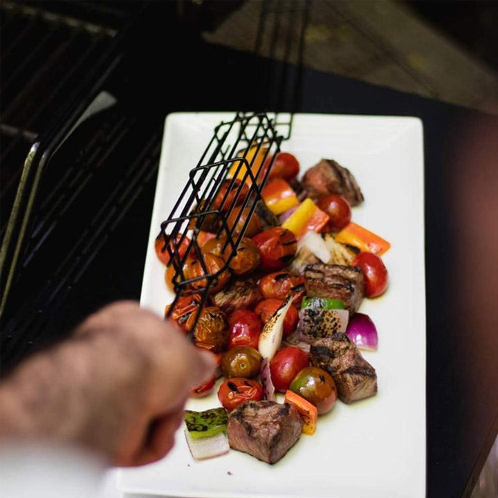 Grill kabob basket with skewered meats and vegetables cooking over open flame, nonstick for easy cleaning.