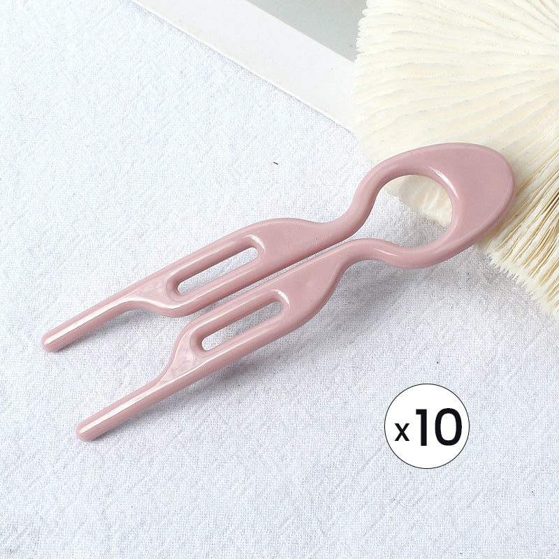 Texture shot of hair being styled with a single hair pin, focusing on its grip for updos.