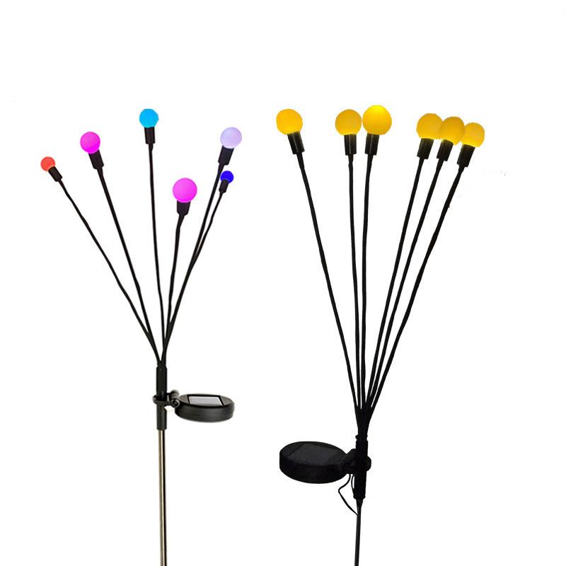 Solar-powered firefly lights adding a whimsical touch to a backyard landscape at night