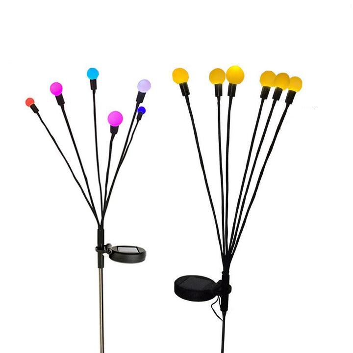 Solar-powered firefly lights adding a whimsical touch to a backyard landscape at night