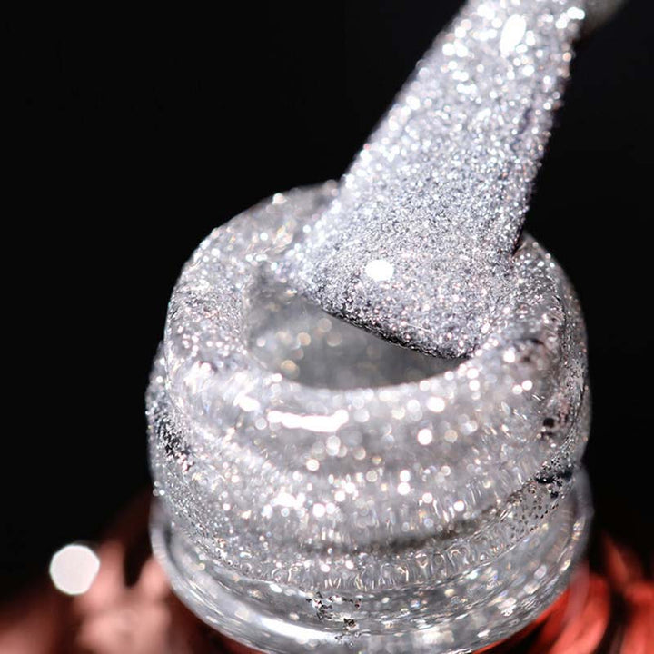 Hand applying sparkling glitter gel nail polish for a professional and long-lasting manicure