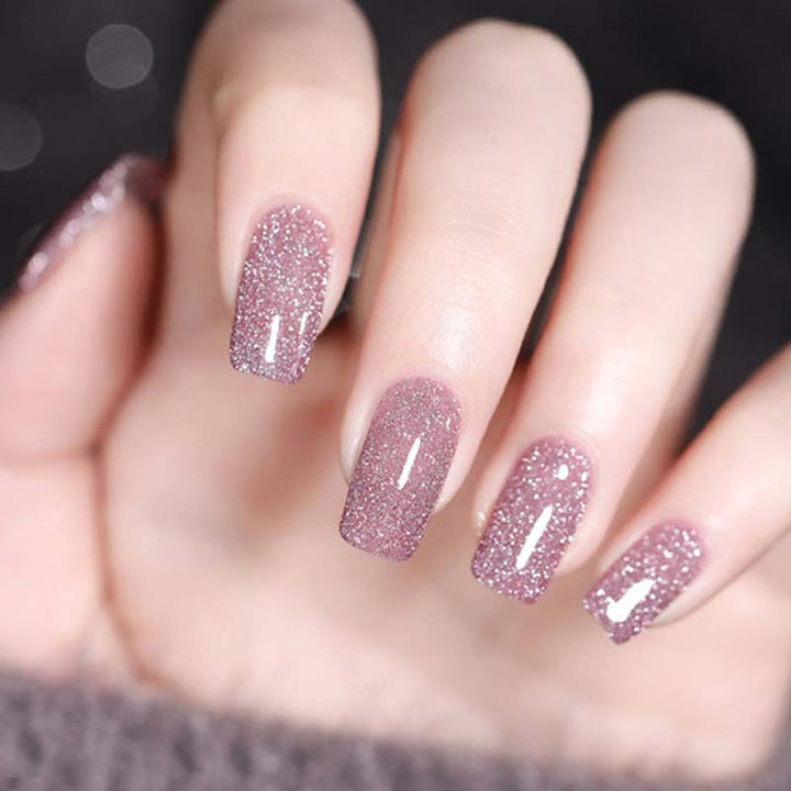 Bottle of long-lasting sparkling glitter gel nail polish next to a finished shimmer nail art
