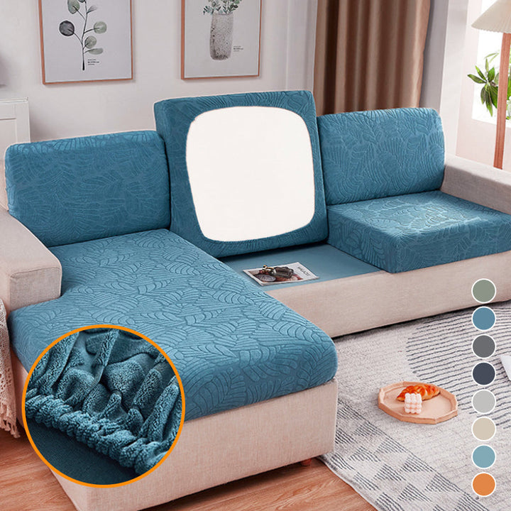 Stretchable polyester sofa cover in a neutral color, protecting a living room couch from wear and pets.