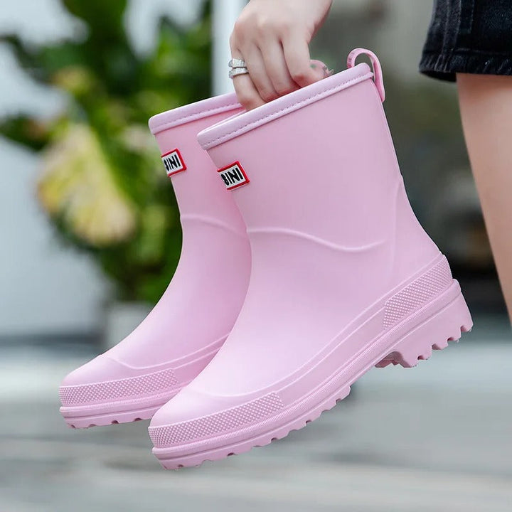 Pink women's stylish waterproof ankle rain boots, slip-on design for wet weather fashion.