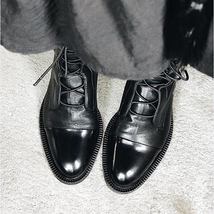 Side view of a women's black leather lace-up ankle boot, showcasing the classic design and comfortable fit.