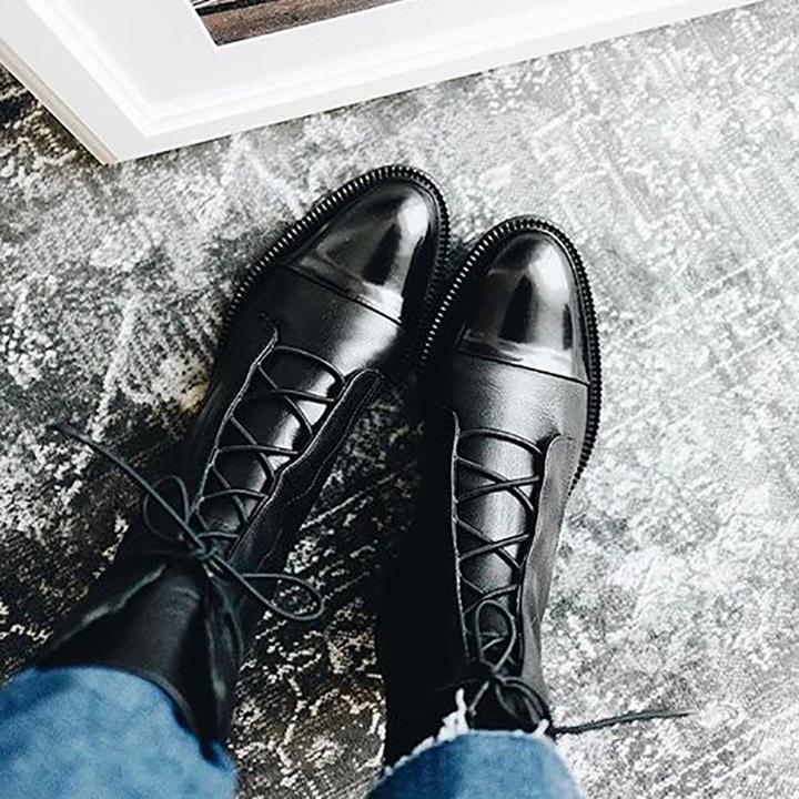 Women's chic black leather lace-up ankle boots, versatile for both casual and semi-formal winter outfits.