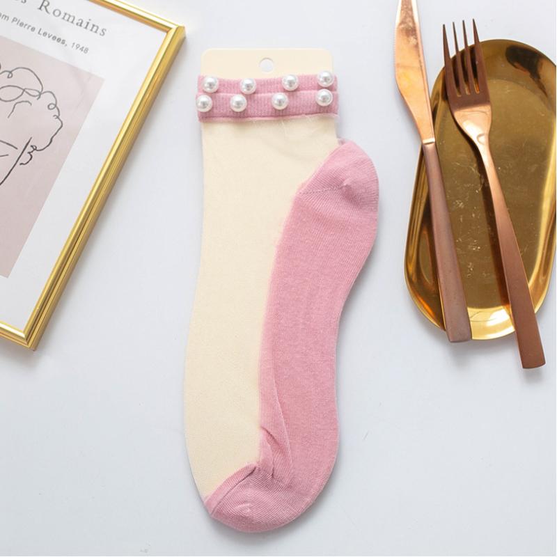 Detailed view of the fishnet pattern and pearls on women's ankle socks.