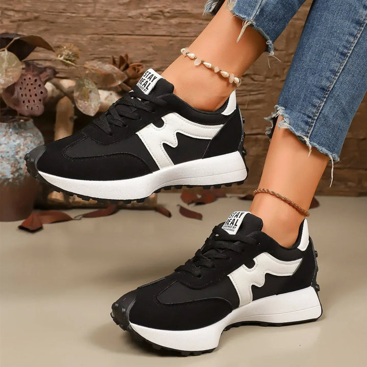 Female platform sneakers, striped detail, lace-up, offering both style and comfort.