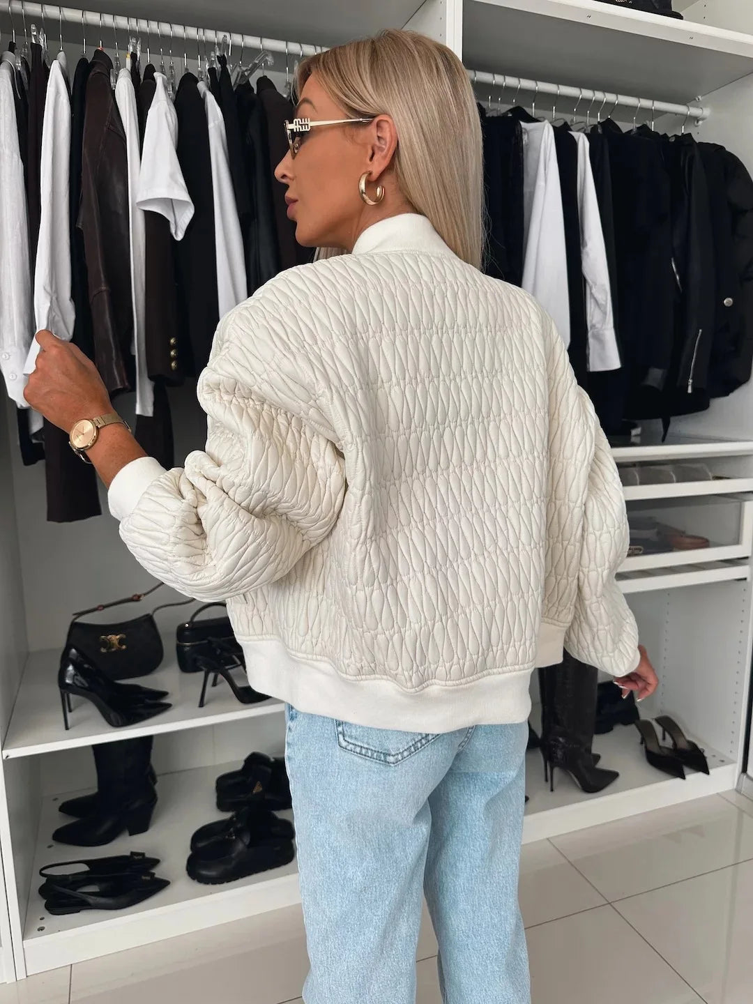Close-up of a women's quilted bomber jacket texture, showcasing stitching