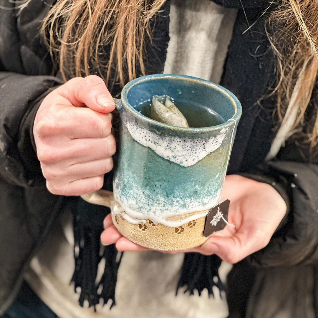 Elegant ocean blue textured mug featuring an embossed paw print, ideal for coffee or tea, unique drinkware