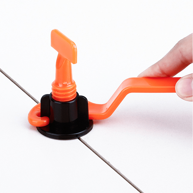 Close-up of a tile leveling clip and wedge, demonstrating lippage control for a smooth tiled surface.