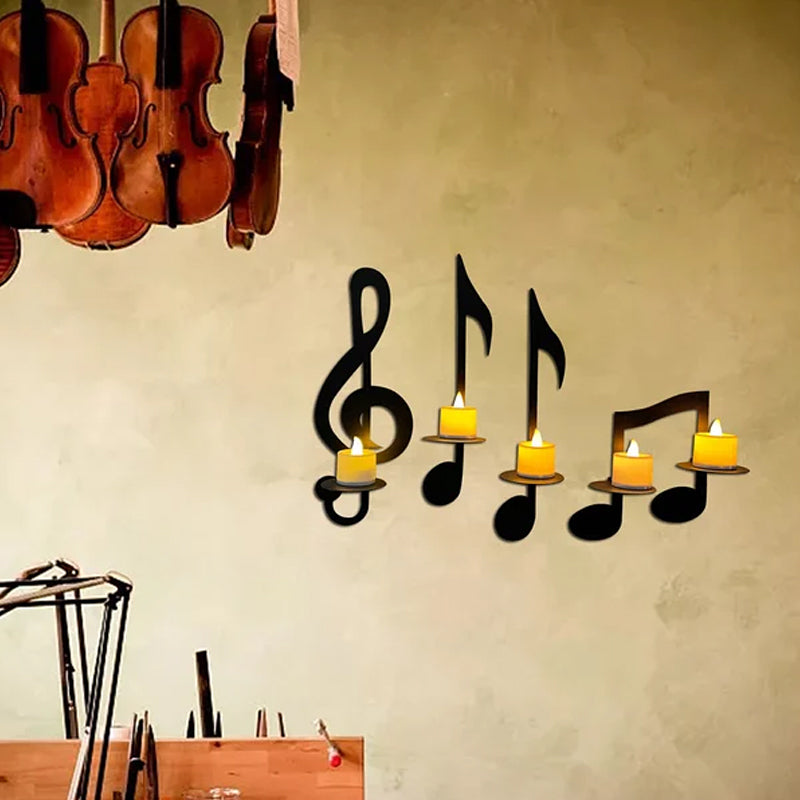 Black metal treble clef and musical notes wall decor with a built-in candle sconce
