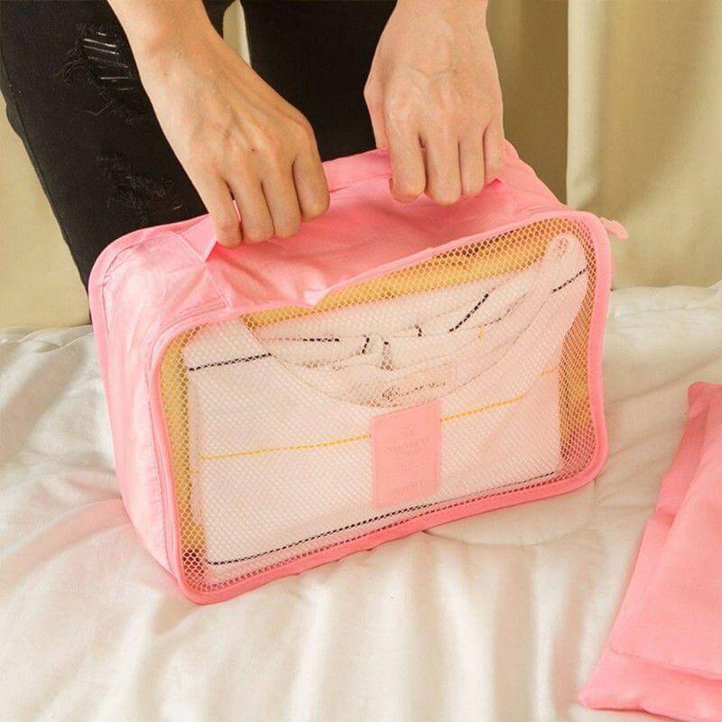 Hand holding a portable travel organizer cube. Easy to carry & fit into any travel bag.