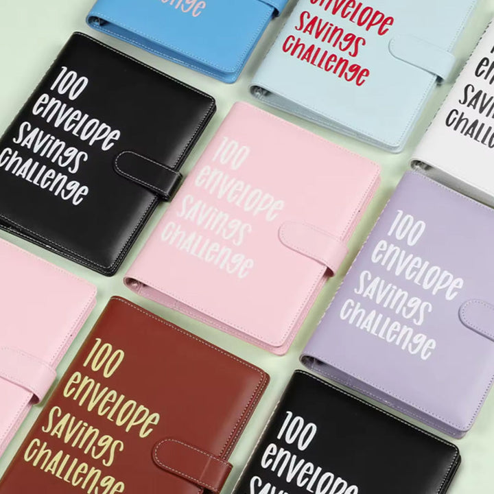 Unisex 100 Envelopes Money Saving Challenge Kit next to a pen, for easy finance tracking