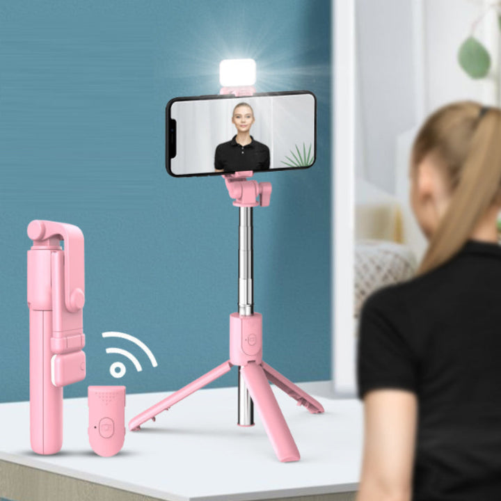 Person taking a selfie with the 6-in-1 Bluetooth selfie stick tripod, fill light activated