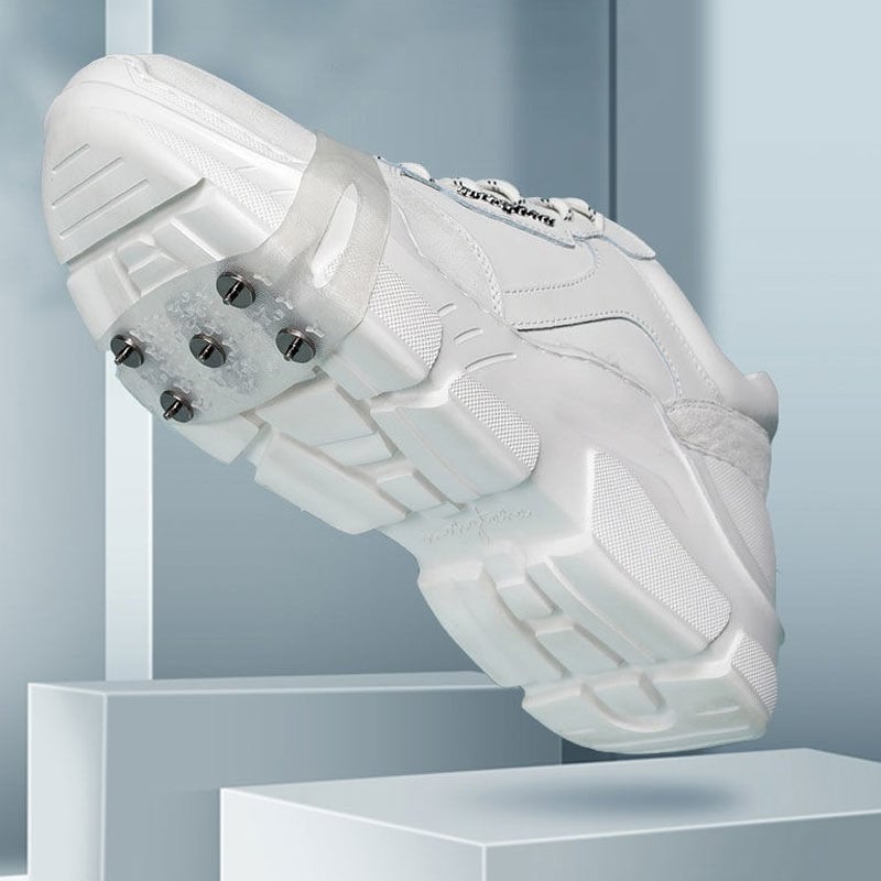 Man's hand holding an ice gripper, showing flexible silicone and robust spikes for footwear