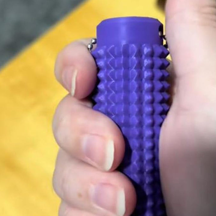 Calming Sensory Spike Keychain next to a laptop, a desktop anxiety relief tool