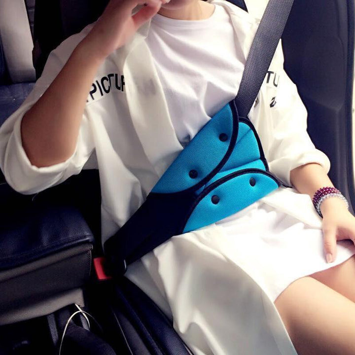 Child using car seat belt adjuster, ensuring proper fit and safety during travel, auto safety.