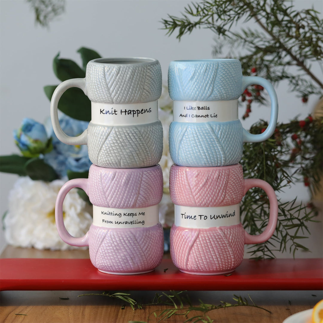 Close-up of a white ceramic mug featuring a vibrant knitting yarn ball graphic; a crafter's delight.