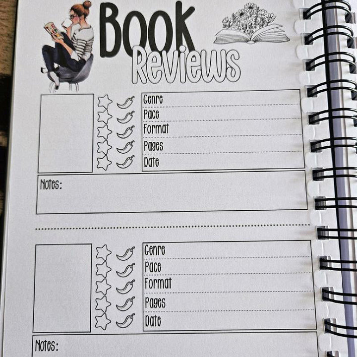 Open creative reading journal displaying a 'Currently Reading' section with colorful pencil strokes.