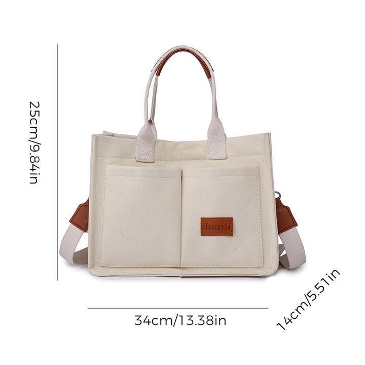 Front zipper pocket detail on a unisex canvas crossbody bag, ideal for quick access items.