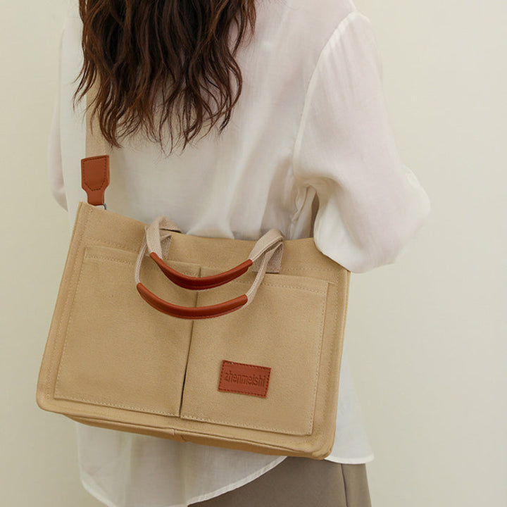 Side view of a spacious canvas shoulder bag, perfect for carrying your daily necessities.