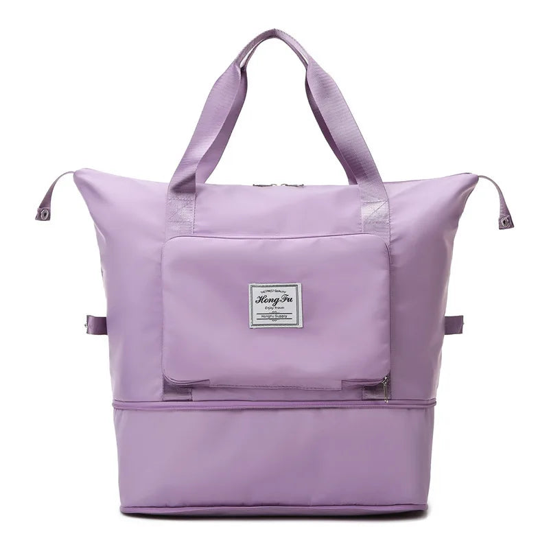 Unisex traveler carrying a lightweight, black foldable duffel bag through an airport terminal.