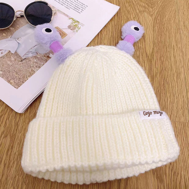 Variety of knit monster hats laid flat, showcasing different colors