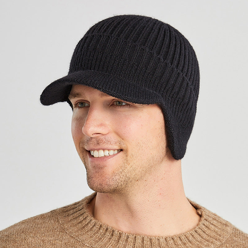 Side profile of a person wearing a beige knitted winter beanie with integrated ear flaps.