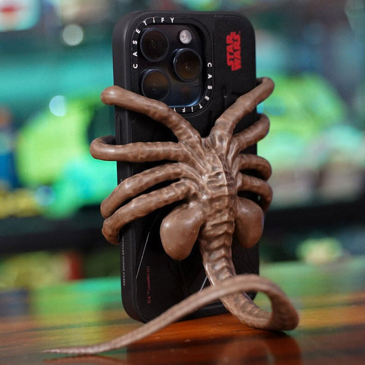 Side view of the Horrible Creature Phone Holder, showcasing its ergonomic phone-holding design.