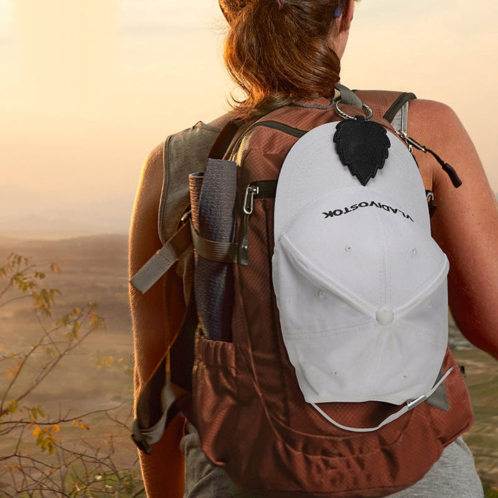 Travel hat holder clip with strong magnet, securing a wide-brimmed hat to a tote bag.