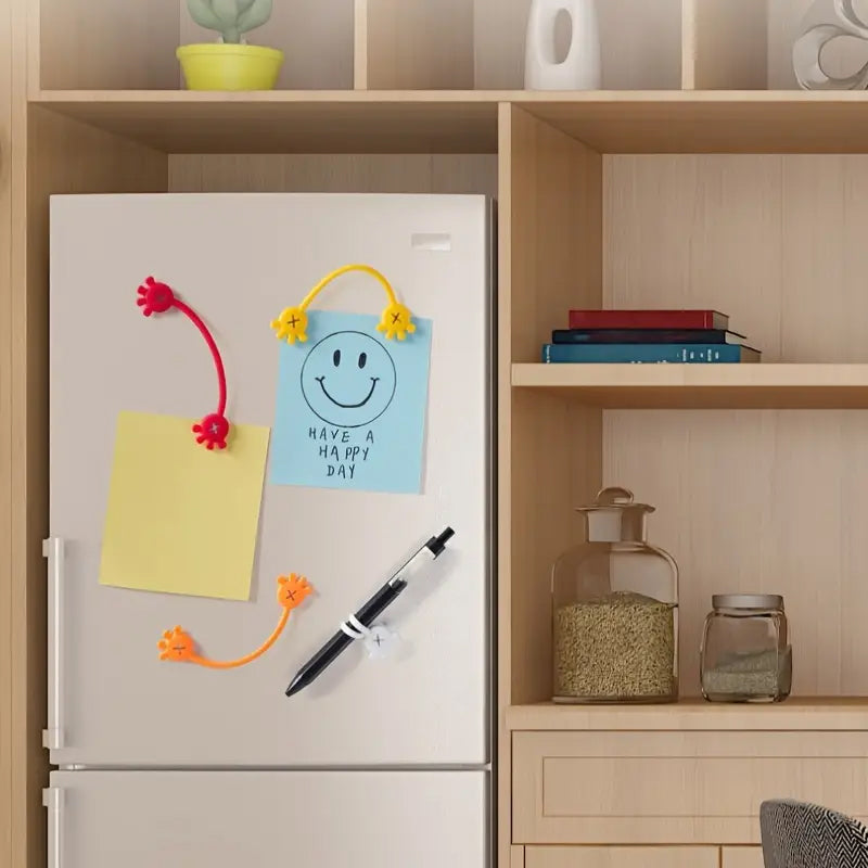 Set of colorful magnetic silicone cable organizer clips (red, blue, black, white) on a marble surface.