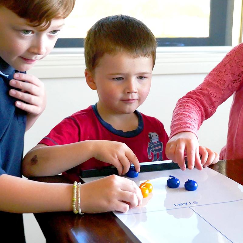Compact tabletop curling game featuring a roll-up mat and miniature balls, perfect for travel and indoor games.
