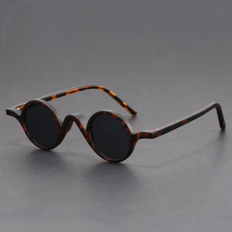 Close-up of unisex sunglasses with a round frame, emphasizing sun protection and modern fashion.