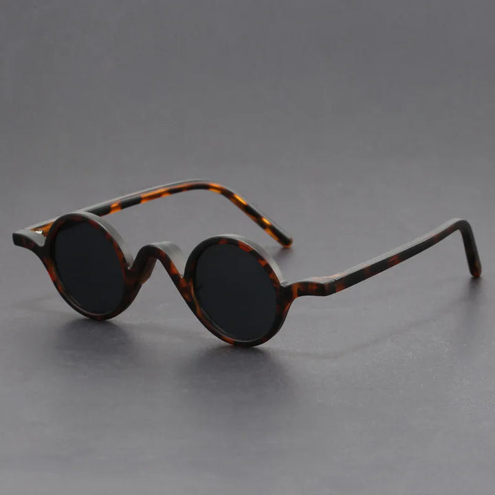 Close-up of unisex sunglasses with a round frame, emphasizing sun protection and modern fashion.