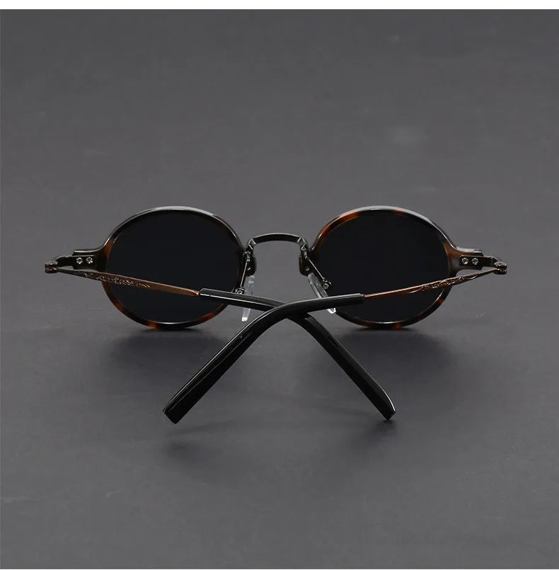 A pair of unisex oval vintage sunglasses showcasing their unique shape and high-quality precision.