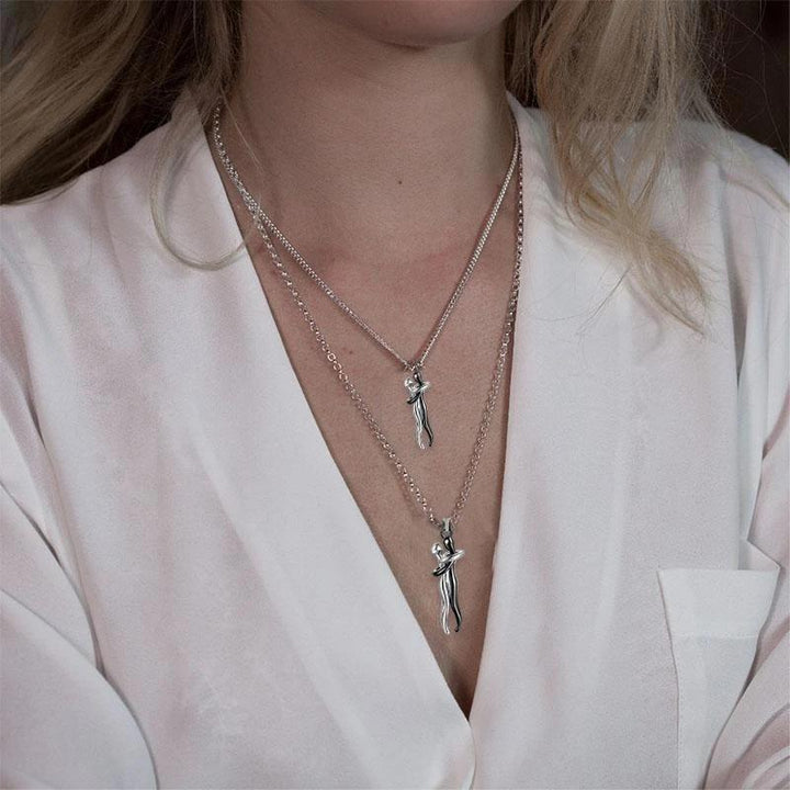 Two figures in an embrace hug pendant on an adjustable silver chain, sentimental jewelry