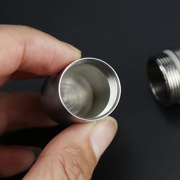 Portable medicine organizer: a waterproof stainless steel pill box on a clean surface