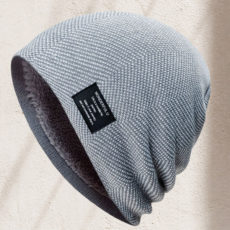 Close-up of an embroidered logo on a unisex thermal knit beanie hat, indicating quality outdoor gear.