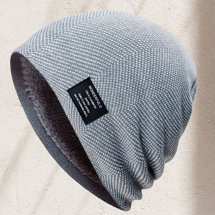 Close-up of an embroidered logo on a unisex thermal knit beanie hat, indicating quality outdoor gear.