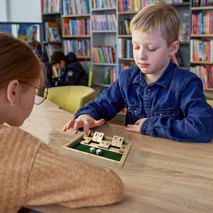 Kids laughing while playing a unisex math board game with dice, fostering family fun
