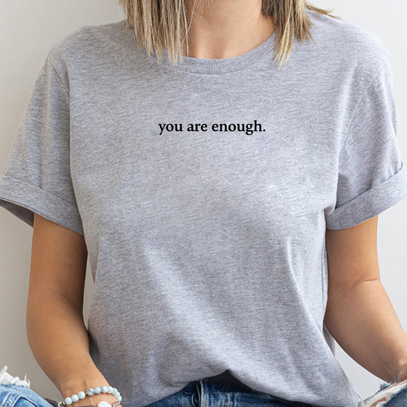 Unisex tee 'You Are Enough' in a lifestyle shot, promoting self-love & mental health.