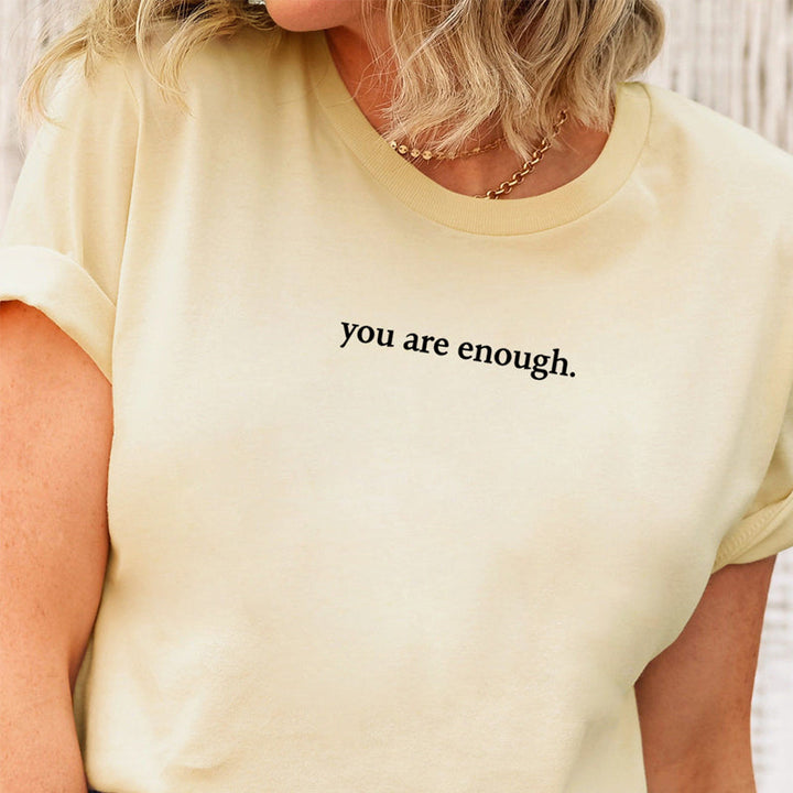 Folded 'You Are Enough' cotton t-shirt, ready as an inspirational comfort wear gift.